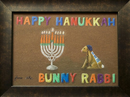 A drawing of a menorah being regarded by a rabbit wearing kippah, tallit, and tefillin between the words ‘HAPPY HANUKKAH’ at the top and ‘from the BUNNY RABBI’ at the bottom.