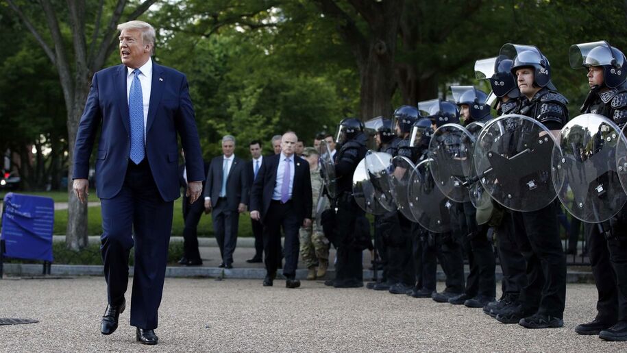 President Donald Trump flanked by riot police in Lafayette Park after it was cleared using tear gas for the president's Monday press event outside St. John's Church across from the White House Monday, June 1, 2020. (AP Photo/Patrick Semansky)