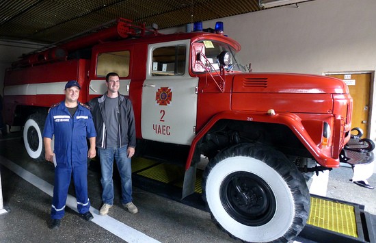 A Chernobyl fireman and a fire chief from Illinois, USA stand next to one of the trucks in the No. 2 fire station garage at Chernobyl Nuclear Power Plant.