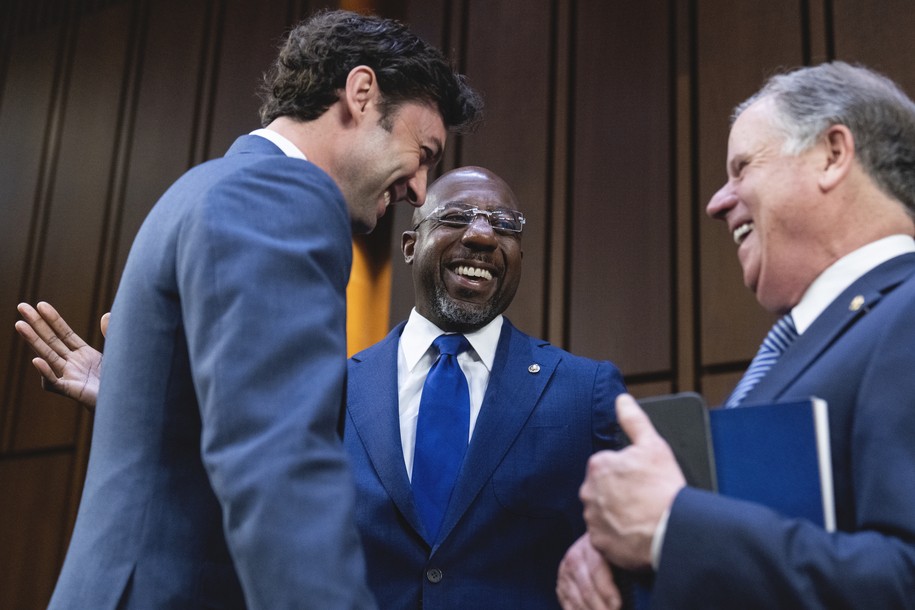 UNITED STATES - MARCH 23: From left, Sens. Jon Ossoff, D-Ga., Raphael Warnock, D-Ga., and former Sen. Doug Jones, G-Ala., talk before Judge Ketanji Brown Jackson, President Biden’s nominee for Associate Justice to the Supreme Court, arrived on the third day of her Senate Judiciary Committee confirmation hearing in Hart Senate Office Building on Capitol Hill, on Wednesday, March 23, 2022. (Tom Williams/CQ Roll Call).