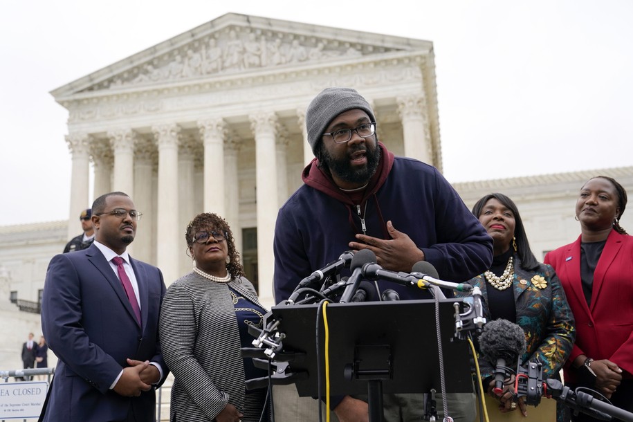 FILE - Evan Milligan, center, plaintiff in Merrill v. Milligan, an Alabama redistricting case that could have far-reaching effects on minority voting power across the United States, speaks with reporters following oral arguments at the Supreme Court in Washington, Oct. 4, 2022. Standing behind Milligan are Milligan's counsel Deuel Ross, from left, Letetia Jackson, Rep. Terri Sewell, D-Ala., and Janai Nelson, President and Director-Counsel of the NAACP Legal Defense Fund. A U.S. Supreme Court decision a decade ago that tossed out the heart of the Voting Rights Act continues to reverberate across the country. Republican-led states continue to pass voting restrictions that, in several cases, would have been subject to federal review had the court left the provision intact. (AP Photo/Patrick Semansky, File)