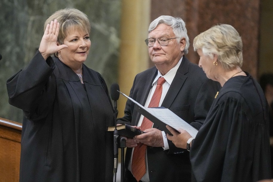 Janet Protasiewicz, left, is sworn as a Wisconsin Supreme Court justice by Supreme Court Justice Ann Walsh Bradley, Tuesday, Aug. 1, 2023, in Madison, Wis. At center is Protasiewicz' husband Greg Sell. (AP Photo/Morry Gash)