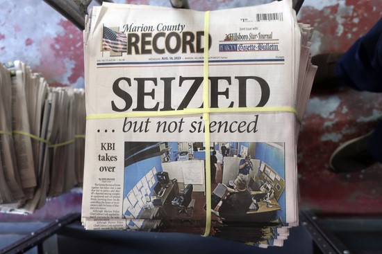 A stack of the latest weekly edition of the Marion County Record sits in the back of the newspaper&#39;s building, awaiting unbundling, sorting and distribution, Wednesday, Aug. 16, 2023, in Marion, Kan. The newspaper&#39;s front page was dedicated to two stories about a raid by local police on its offices and the publisher&#39;s home on Aug. 11, 2023. (AP Photo/John Hanna)