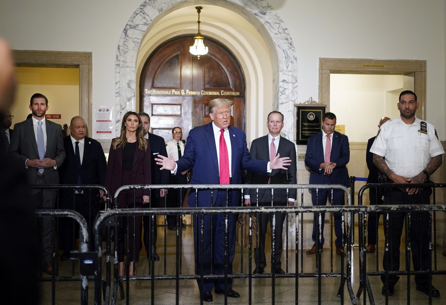 Former President Donald Trump, center, arrives for his civil business fraud trial at New York Supreme Court, Tuesday, Oct. 17, 2023, in New York. Trump's son, Eric Trump, stands at left. (AP Photo/Seth Wenig)