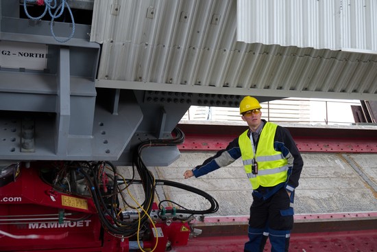 An engineer working on the New Safe Confinement at Chernobyl points to the hydraulic mechanisms that will move the giant structure into place.