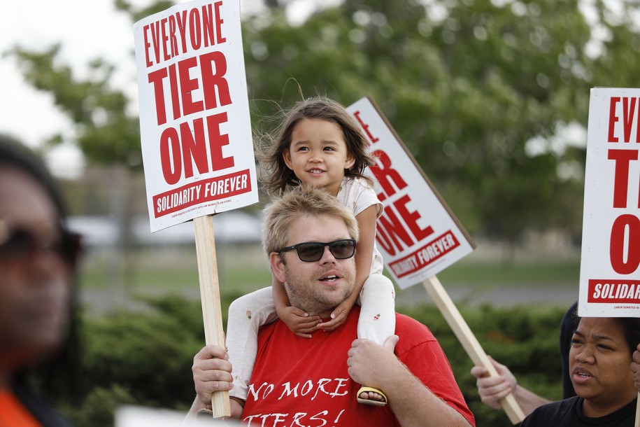 DETROIT, MI - SEPTEMBER 25: Steve Donagan with UAW Local 22 of Royal Oak, Michigan, carries his three-year-old daughter Regina on his shoulders as he walks the picket line with striking United Auto Workers (UAW) union members at the General Motors Detroit-Hamtramck Assembly Plant on September 25, 2019 in Detroit, Michigan. The UAW called a strike against GM at midnight on September 15th, the unions first national strike since 2007. This is the unions longest national strike since 1970. (Photo by Bill Pugliano/Getty Images)