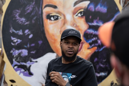 LOUISVILLE, KY - MARCH 13: Kenneth Walker, boyfriend of Breonna Taylor, stands in front of a portrait of Taylor during a protest memorial for her in Jefferson Square Park on March 13, 2021 in Louisville, Kentucky. Today marks the one year anniversary since Taylor was killed in her apartment during a botched no-knock raid executed by LMPD. (Photo by Jon Cherry/Getty Images)