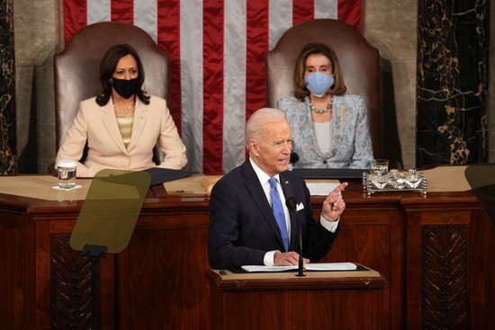 WASHINGTON, DC - APRIL 28: U.S. President Joe Biden addresses a joint session of Congress as Vice President Kamala Harris (L) and Speaker of the House U.S. Rep. Nancy Pelosi (D-CA) (R) look on in the House chamber of the U.S. Capitol April 28, 2021 in Washington, DC. On the eve of his 100th day in office, Biden spoke about his plan to revive Americaâ€™s economy and health as it continues to recover from a devastating pandemic. He delivered his speech before 200 invited lawmakers and other government officials instead of the normal 1600 guests because of the ongoing COVID-19 pandemic. (Photo by Doug Mills - Pool/Getty Images)