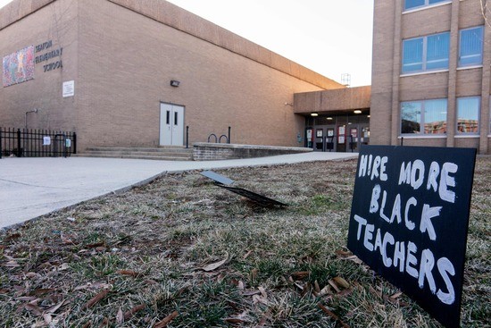 A sign reading Hire More Black Teachers is displayed in front of an elementary school in Washington, DC, on February 19, 2022. (Photo by Stefani Reynolds / AFP) (Photo by STEFANI REYNOLDS/AFP via Getty Images)