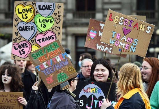 Trans Rights activists hold placards while taking part in the "Furies against Fascism" counter protest to the "Let Women Speak" rally in Glasgow, on February 5, 2023. - Transgender issues are in the spotlight in Scotland after its devolved government passed legislation in December to make it easier for people to self-identify their gender.Some feminist activists criticised the Scottish legislation precisely because they feared it would allow sexual predators to gain access to women-only spaces, despite provisions in the text. (Photo by Andy Buchanan / AFP) (Photo by ANDY BUCHANAN/AFP via Getty Images)