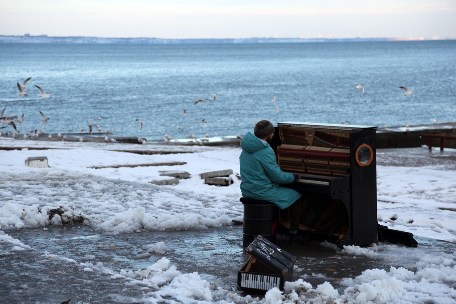 ODESA, UKRAINE - NOVEMBER 27: Musician Ihor Yanchuk plays the piano on the snowy Lanzheron beach on November 27, 2023 in Odesa, Ukraine. On November 26, an anticyclone came to Ukraine with strong winds and snowfalls. The situation is difficult in Odesa and Odesa Oblast. Over 100 trees fell on the streets, damaging power lines, which caused interruptions in the supply of electricity to houses and the impossibility of operating electrical transport. 3 people froze to death on the street. According to city authorities, almost 1,900 employees of Odesa public utilities are eliminating the consequences of the bad weather that hit the city on November 26. (Photo by Viacheslav Onyshchenko/Global Images Ukraine via Getty Images)