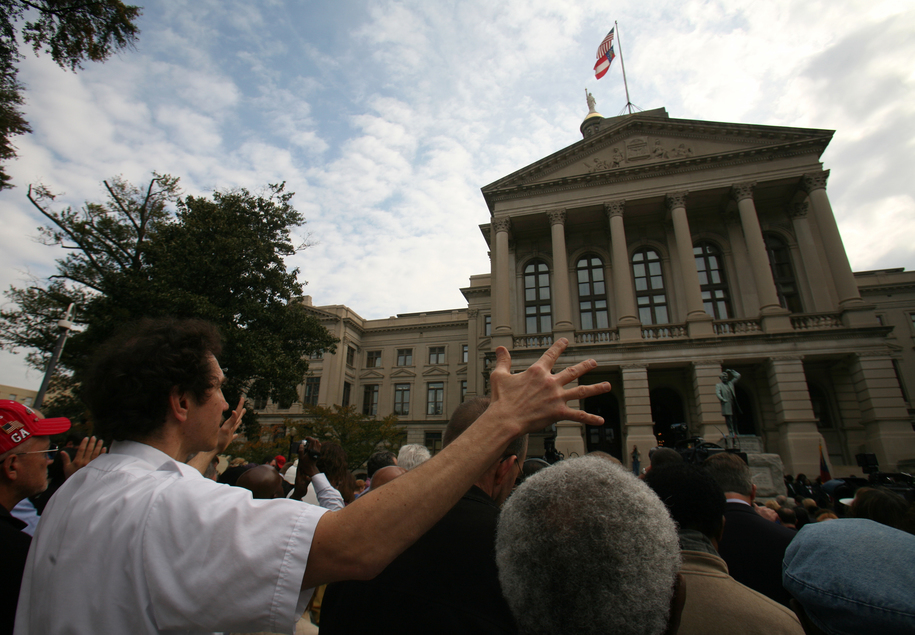 ATLANTA - NOVEMBER 13:  A man calling himself 'GOF', God's Own Fool, raises his hands in prayer along with hundreds of other Georgia residents in front of the Georgia State Capitol in Atlanta, Georgia November 13, 2007.  Georgia citizens, politicians and religious leaders were invited to the public prayer service to pray for relief to Georgia's drought.  (Photo by Jessica McGowan/Getty Images)