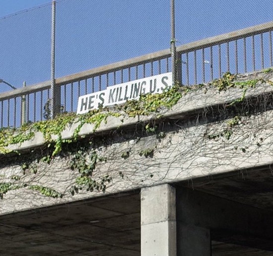 He's Killing U.S. sign over Pasadena Freeway