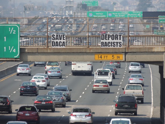 Save DACA Deport Racists sign over I-80.