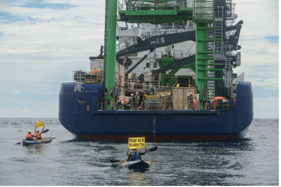 Greenpeace activists next to the MV Coco, a vessel researching deep sea mining on behalf of The Metals Company.